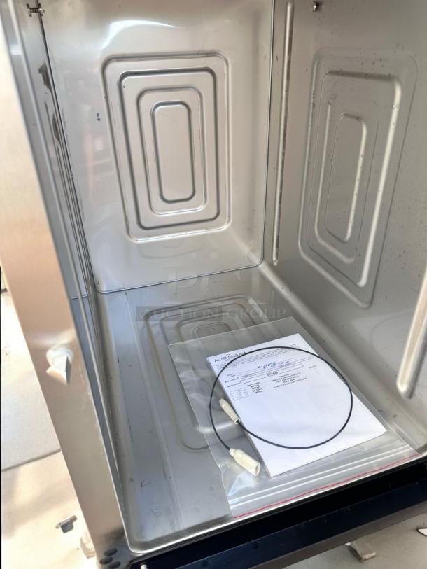 Brand new Alto-Shaam 1000-TH low-temp cook and hold oven. Interior view with factory-sealed accessories and manual.