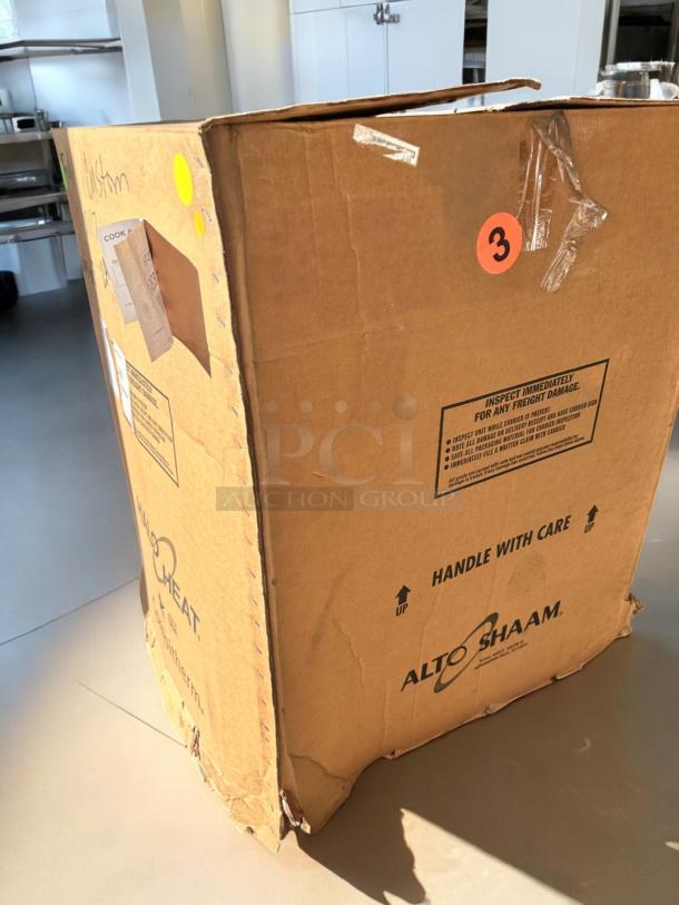 Brand new Alto-Shaam 1000-TH low-temp cook & hold oven in sealed box. Box shows handling labels and model marking.