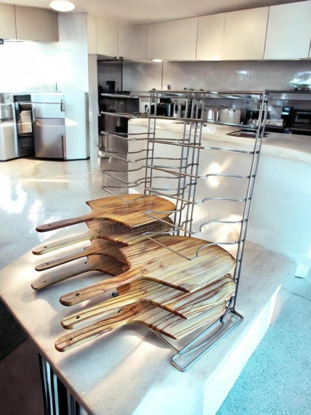 Chrome wire pizza peel rack with 8 wooden paddles, 11"D x 10"W x 28"H, in outstanding condition. Heavy-duty, space-saving design.