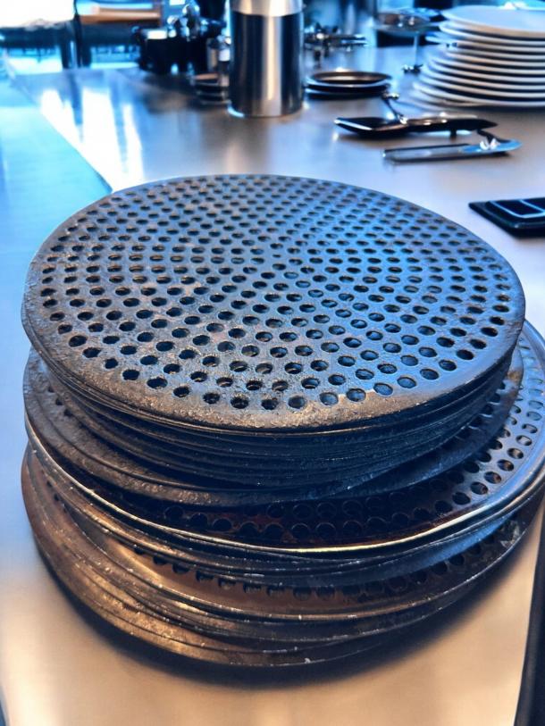 Stack of 17 perforated pizza disks, 14" diameter, heavy-duty, pre-seasoned, in superb condition, clean and ready for use.