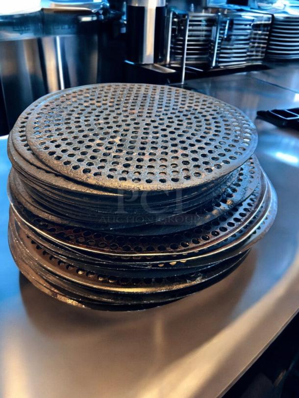 Stack of 17 pristine 14" perforated pizza disks, pre-seasoned, heavy-duty, ready for use. Clean and in superb condition.