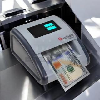 Cassida InstaCheck automatic currency detector in superb condition, displaying "PASS" on screen as it scans a bill, fully tested.