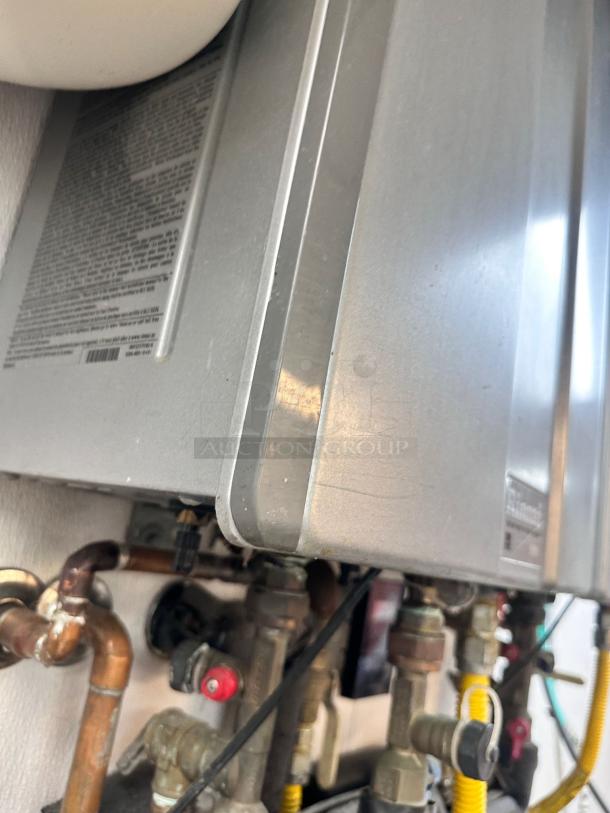 Superb condition Rinnai RUC98iN tankless water heater, natural gas model. Fully tested and working, with visible piping connections.