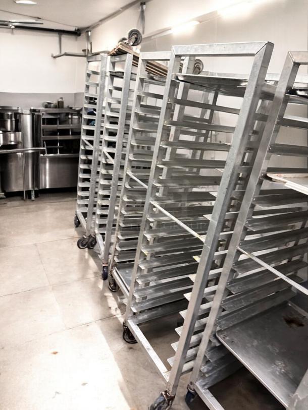 Alexander Industries full-height mobile pan racks, NSF certified, in outstanding condition, featuring durable wheels and metal construction.