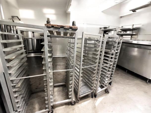 Alexander Industries full-height mobile pan racks, NSF certified, in outstanding condition, featuring multiple tiers and swivel casters.
