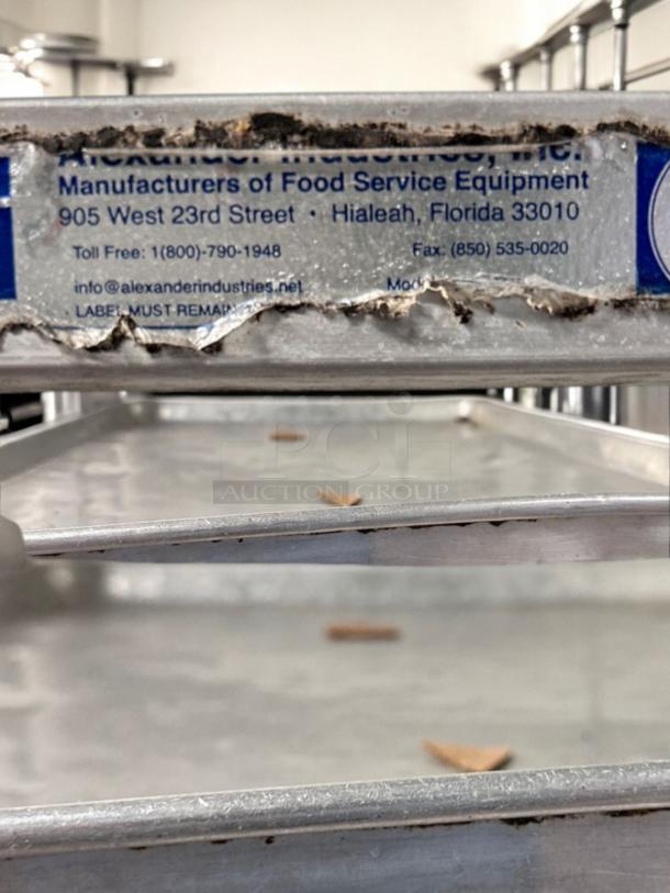 NSF-certified full-height mobile pan racks by Alexander Industries in working condition. Manufacturer details visible.