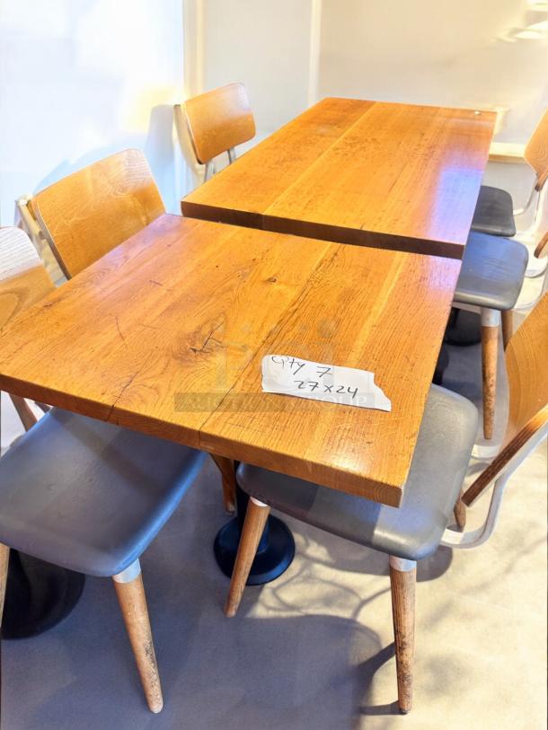Solid wood café table with steel base, 27"x24". Excellent condition, commercial grade, seating shown. Quantity: 7.
