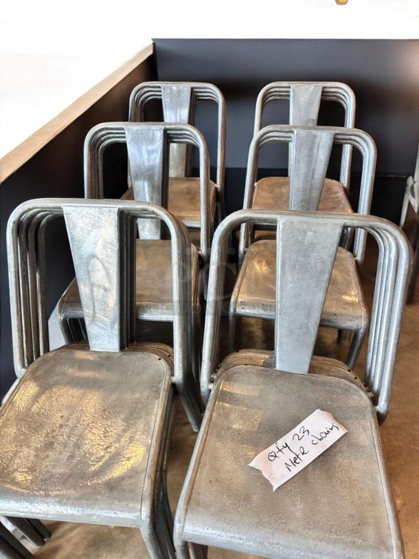 Stackable industrial metal dining chairs, immaculate condition, set of 23, commercial ready, labeled "Qty 23 Metal Chairs".