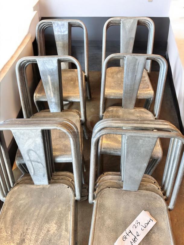 Stackable industrial metal dining chairs, immaculate condition, set of 23, clean and commercial-ready, shown in a stack.