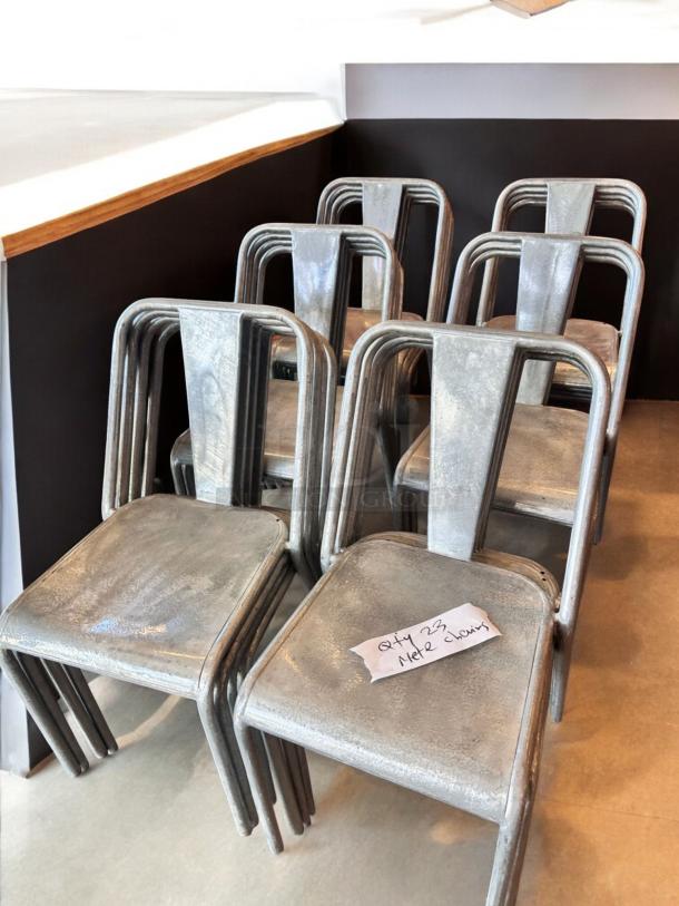 Immaculate condition industrial metal dining chairs, stackable, quantity 23, clean and commercial ready, with label visible.