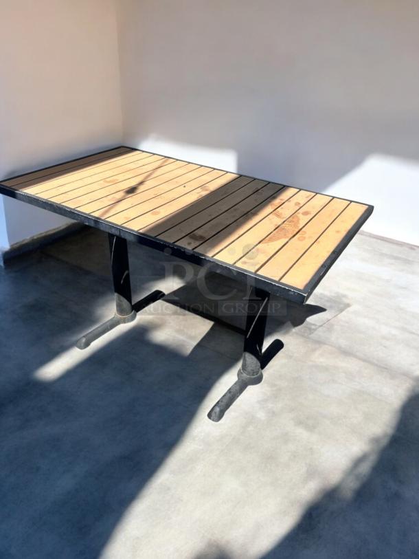 Like-new commercial outdoor patio table, slatted wood top, heavy-duty black base. Fully inspected, ready for use.