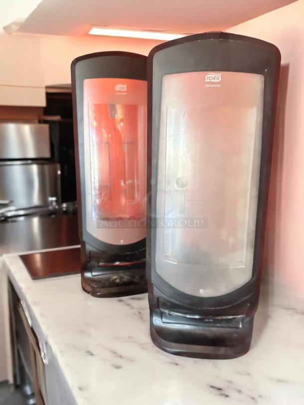 Tork Xpressnap tabletop napkin dispensers in black, very good condition, fully tested and functional, visible brand logo.