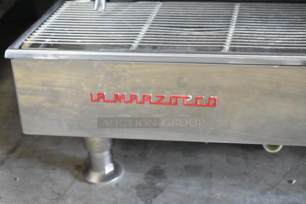 La Marzocco stainless steel commercial 2 group espresso machine with 2 steam wands, red logo, countertop model.