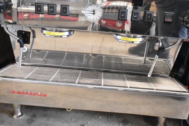 La Marzocco stainless steel 2-group espresso machine with 2 steam wands, commercial use, excellent condition, visible branding.