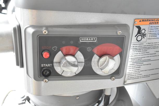 Hobart Legacy HL400 commercial mixer control panel with stop/start buttons and speed settings, warning label visible.