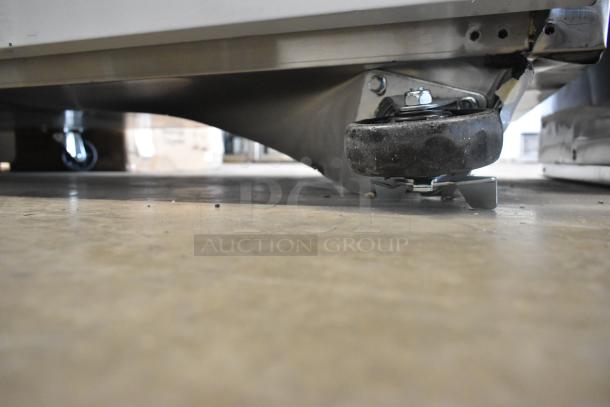 Close-up of a caster on a 2024 Avantco 178SSWD3R stainless steel worktop refrigerator, showing minor scratch.