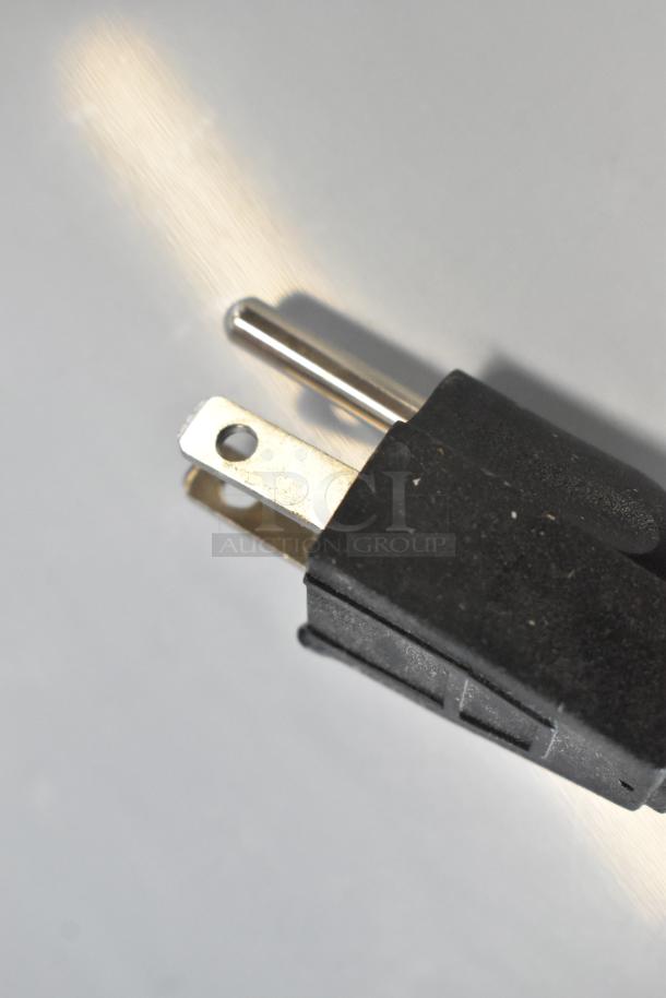 Close-up of a black electrical plug with metal prongs, part of the Avantco 194MCH430A ice machine.
