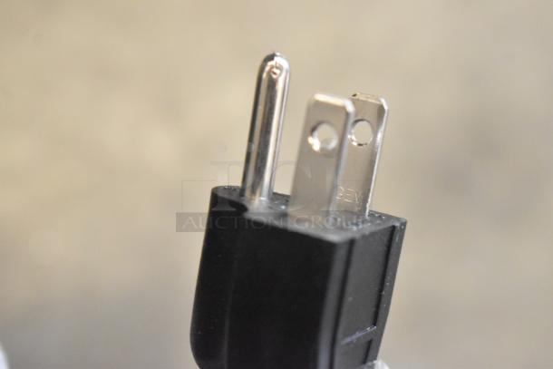 Close-up view of a power plug for the ServIt 423OAM138D 48" slanted heated display merchandiser, 120V, 1 phase.