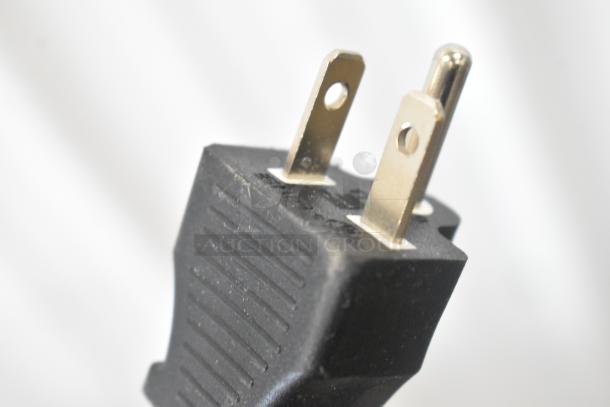 Close-up of a black electrical plug with two flat prongs and one round prong, part of Avantco 177EG24N griddle.