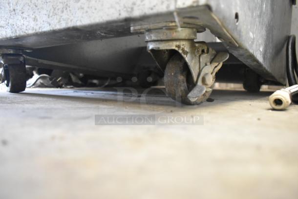 BKI HSS2-4T floor style merchandiser with 3 tiers on commercial casters, showing wear. 208V, 1 Phase.