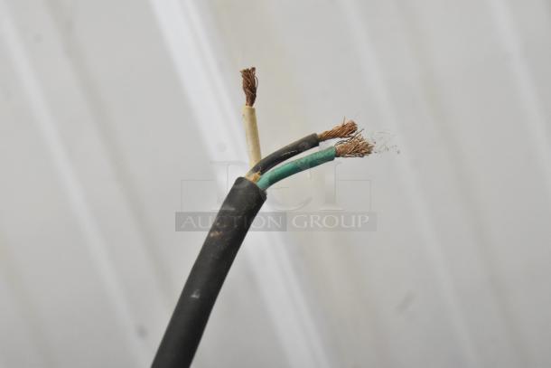 A frayed electrical cable with exposed copper wires, showing wear and requiring repair for safe use.