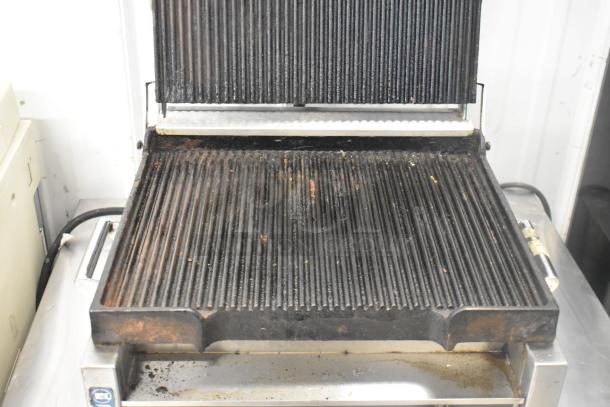 Waring WPG250 stainless steel panini press, commercial countertop model. Visible wear on grill plates, 120 volts, 1 phase.