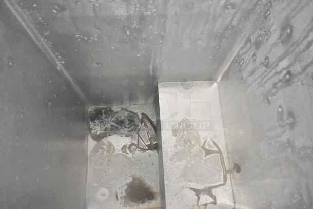 Interior view of Midea MRC04M3AWW chest freezer, showing clean, metallic interior with minor frost. Model and make not visible.