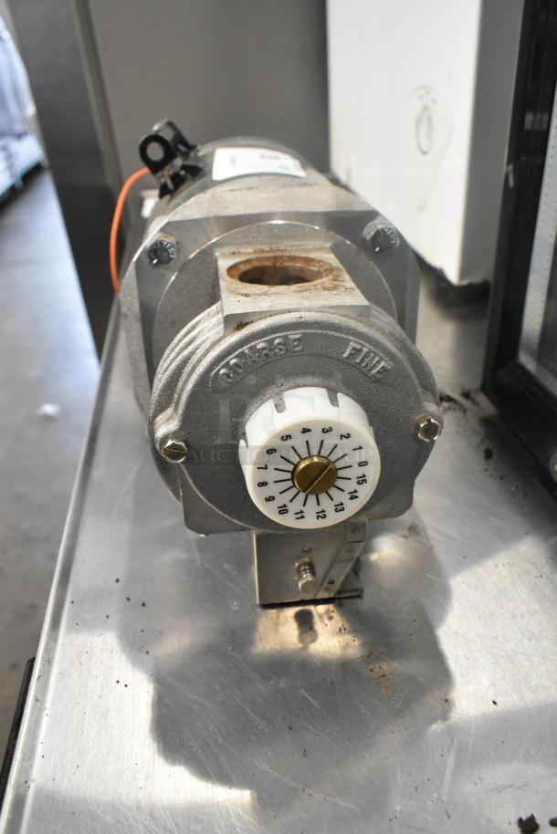 Bluffton 1101007735 Motor, 115V, 1 Phase. Metal housing, visible dial, and mounting bracket. Slight rust on surface.