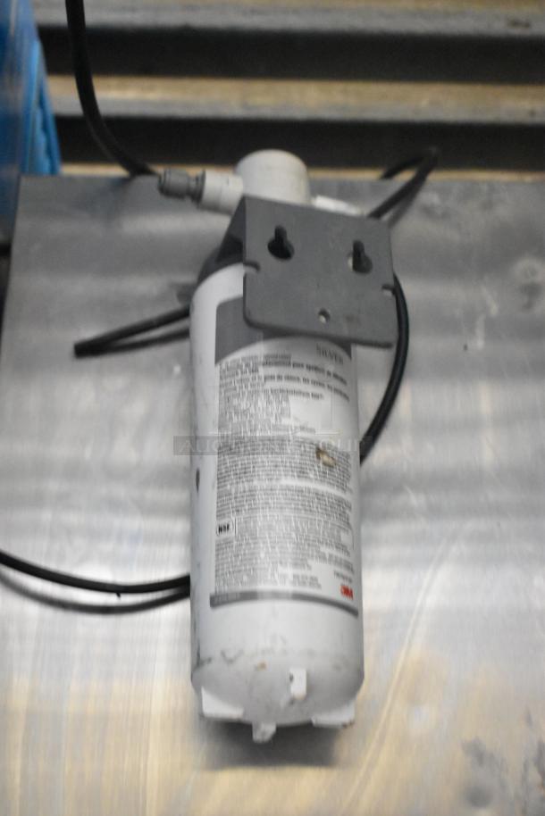 Follett 7CI100A metal countertop ice machine and water dispenser on a metal surface, cables attached, 115 volts, 1 phase.