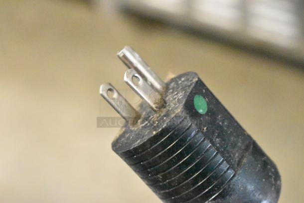 Close-up of a three-prong plug for the Follett 7CI100A ice machine, showing its condition and design details.