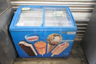 AHT RIO S 100 chest freezer, metal, on commercial casters. Features Nestle branding. 115 volts, 1 phase, model RIO S 100.