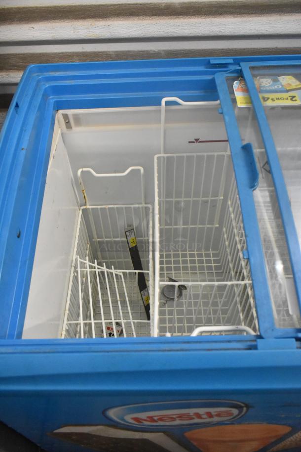 AHT RIO S 100 metal chest freezer merchandiser, blue exterior, sliding glass lid, commercial casters, 115 volts, 1 phase.