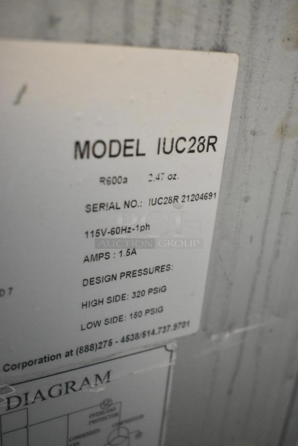 Label on Ikon IUC28R stainless steel undercounter freezer detailing model, serial number, voltage, and pressure specs.