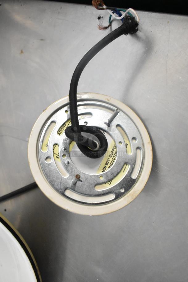 Two metal light fixtures with visible wiring and mounting plate. Features include a circular design and heat-resistant marking.