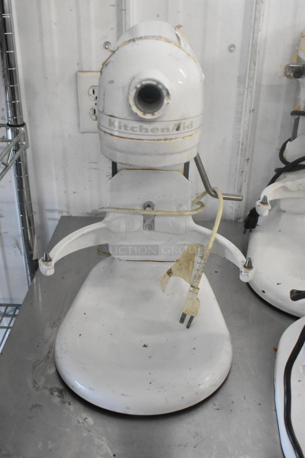 KitchenAid KV25G0XWW/KSMC50S white metal countertop mixer, 5-quart capacity, with visible wear and plug.