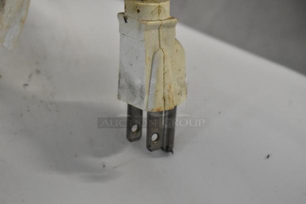 Close-up of a three-pronged power plug for a KitchenAid countertop mixer, showing wear and discoloration.