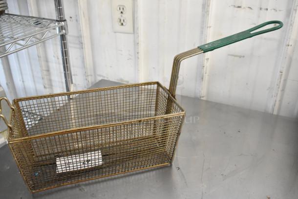Metal fry basket with long green handle, mesh design. Slight wear, suitable for commercial use. Includes bid label.