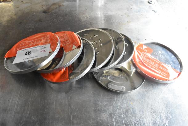 8 KitchenAid metal food processor blades, various designs, in good condition with visible safety labels. Quantity label indicating 8 pieces.