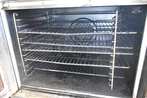 Blodgett stainless steel gas convection oven with view-through doors, metal racks, and thermostatic controls on casters.