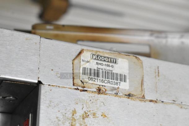 Blodgett SHO-100-G stainless steel convection oven tag, showing model and serial number, affixed to the oven's door.