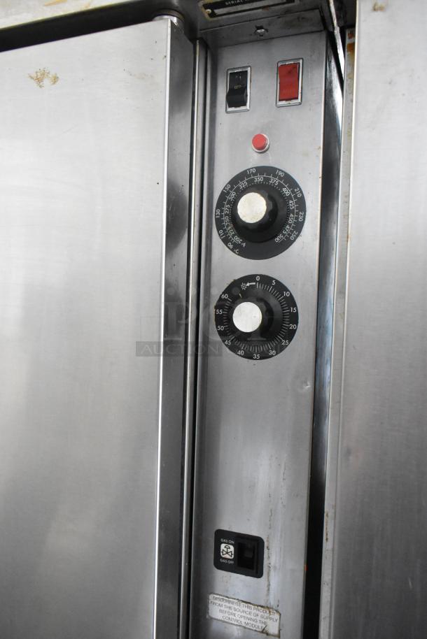 Blodgett stainless steel gas convection oven with metal racks, thermostatic controls, on commercial casters. Slight surface wear.