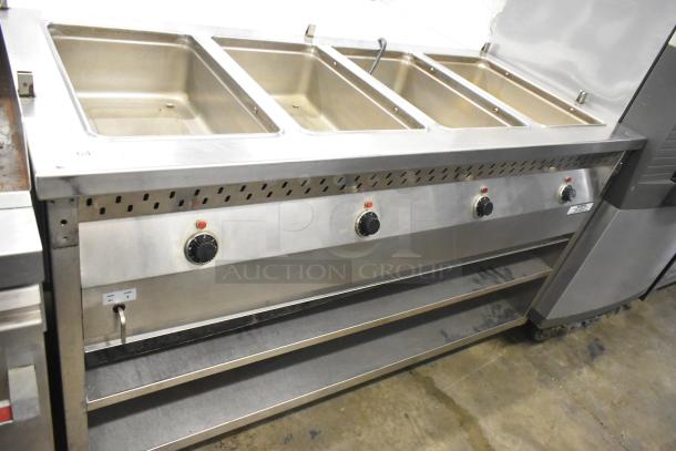 Stainless steel 4-well steam table with under shelf and commercial casters, in good condition, with control knobs.