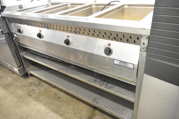 Stainless steel commercial 4 well steam table with under shelf, on commercial casters. Features control knobs and warning label.