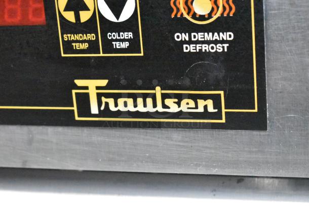 Traulsen RAC-37 label on stainless steel commercial cooler with temperature and defrost controls displayed.