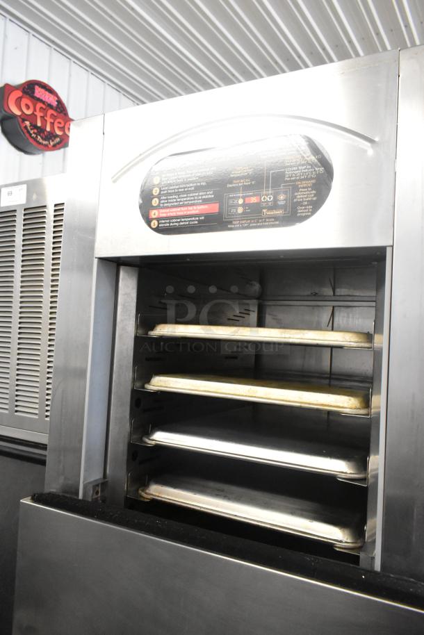 Traulsen RAC-37 stainless steel air curtain cooler with two doors and commercial casters. Model visible on top label.