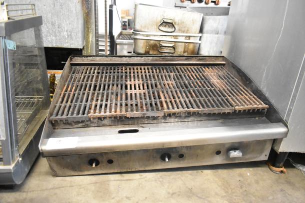 Stainless steel commercial countertop gas charbroiler grill with cast iron grates, adjustable controls, used condition.