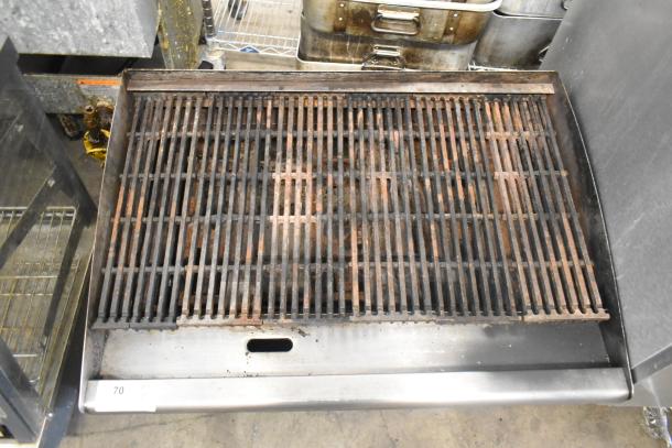 Stainless steel commercial countertop gas charbroiler grill with cast iron grates, used condition. Model tag not visible.