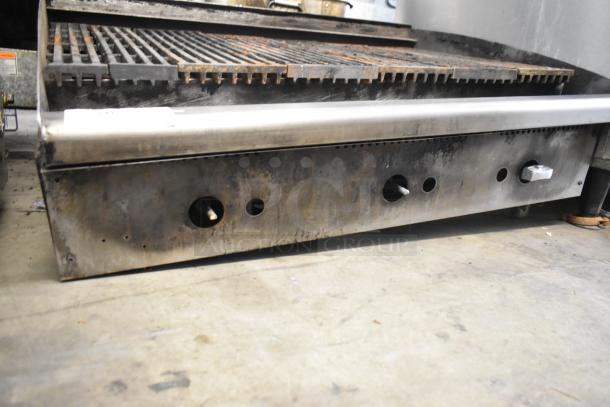 Stainless steel commercial countertop gas charbroiler grill with sturdy grates. Moderate wear, functional knobs visible.