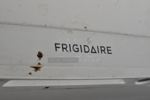 Frigidaire FFFC25M4TW chest freezer with hinge lid, showing exterior markings. 115V, 1 phase. Visible wear and stains.