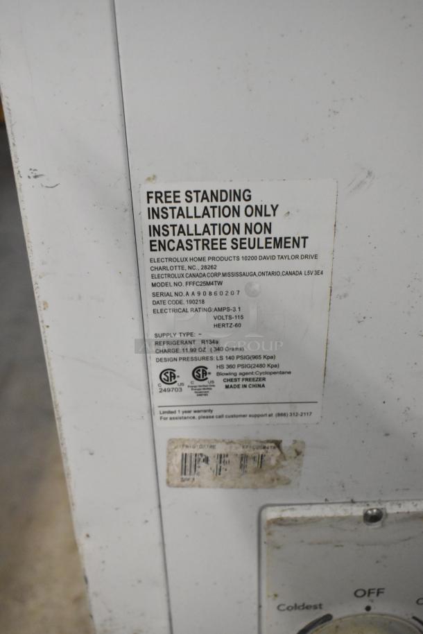 Frigidaire FFFC25M4TW chest freezer with hinge lid. Features 115 volts, 1 phase, freestanding. Visible label with specs.